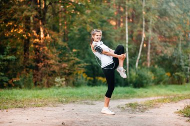 Sonbahar sonbahar ormanlarında koşan bir kadın. Sağlıklı bir yaşam tarzı. Etnik Kafkas fitness modeline uygun.