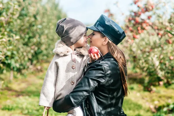 Mom and her baby girl walking and picking apples in the garden. harvesting autumn. apple orchard, wild garden — Stock Photo, Image