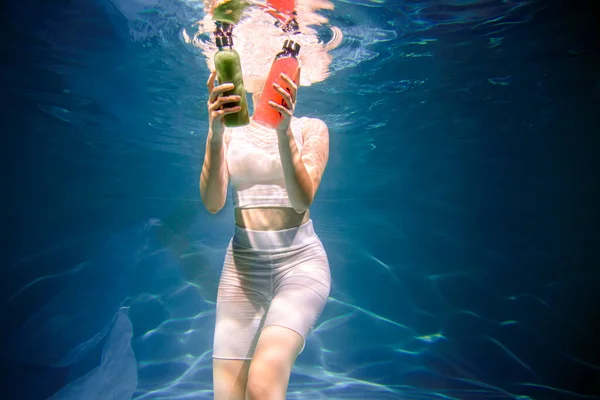 Fitness-Mädchen mit buntem Smoothie. Frische unter Wasser, Schwimmen und Tauchen. — Stockfoto