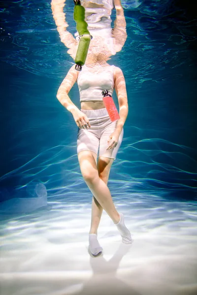 Fitness girl with colorful smoothie. Freshness under water, swims and dives. — Stock Photo, Image