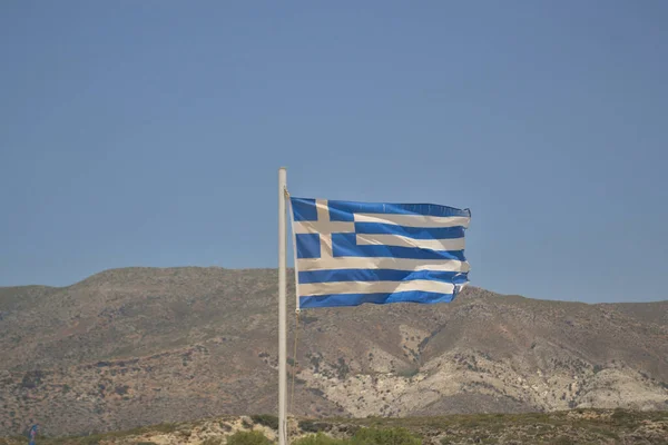 Греческий флаг на фоне гор — стоковое фото