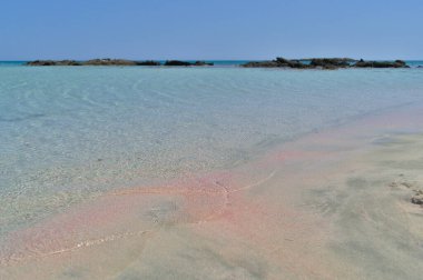 Mavi suyu ve pembe kumu olan bir cennet kumsalı..