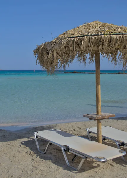 Sonnenliege und Sonnenschirm an einem schönen Sandstrand. — Stockfoto