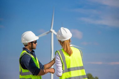 Rüzgar türbini çiftliğinde çalışan mühendis ekibi. Alternatif enerji kavramına göre rüzgar jeneratörüyle yenilenebilir enerji.