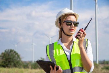 Rüzgar türbini çiftliğinde çalışan mühendis ekibi. Alternatif enerji kavramına göre rüzgar jeneratörüyle yenilenebilir enerji.