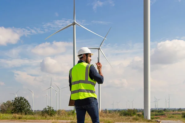 engineer team working in wind turbine farm. Renewable energy with wind generator by alternative energy concept. worker foreman engineer works with the walkie-talkie to order the work.