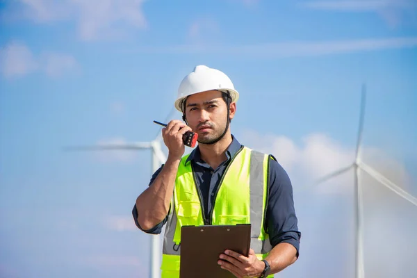 engineer team working in wind turbine farm. Renewable energy with wind generator by alternative energy concept. worker foreman engineer works with the walkie-talkie to order the work.