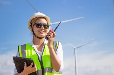 Rüzgar türbini çiftliğinde çalışan mühendis ekibi. Alternatif enerji kavramına göre rüzgar jeneratörüyle yenilenebilir enerji.