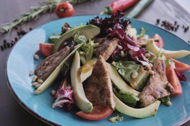 Ahşap masada ızgara sığır eti salatası, gün ışığı.