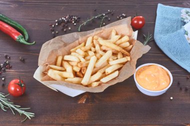 Sebzeli patates kızartması ve ahşap üzerine sos. Düz yatar, ruh hali vurur