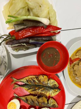 Yanında haşlanmış sebze, haşlanmış yumurta, kızarmış balık ve pilav..