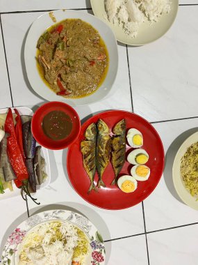 Yanında haşlanmış sebze, haşlanmış yumurta, kızarmış balık ve pilav..