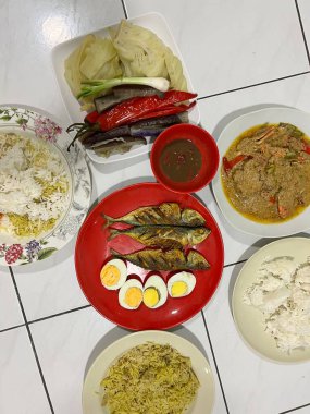 Yanında haşlanmış sebze, haşlanmış yumurta, kızarmış balık ve pilav..