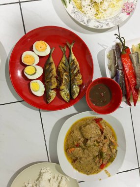 Yanında haşlanmış sebze, haşlanmış yumurta, kızarmış balık ve pilav..