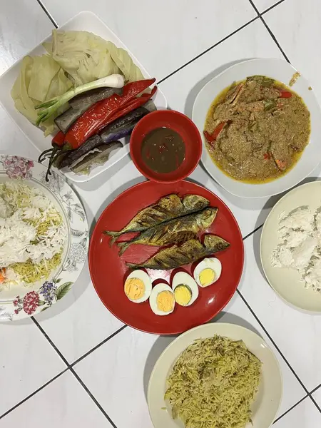 Yanında haşlanmış sebze, haşlanmış yumurta, kızarmış balık ve pilav..