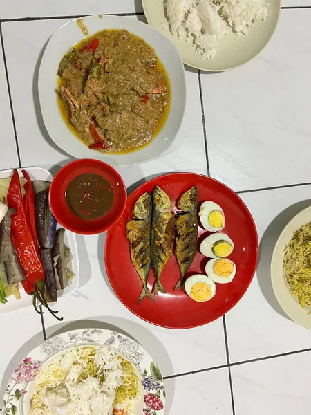 Yanında haşlanmış sebze, haşlanmış yumurta, kızarmış balık ve pilav..