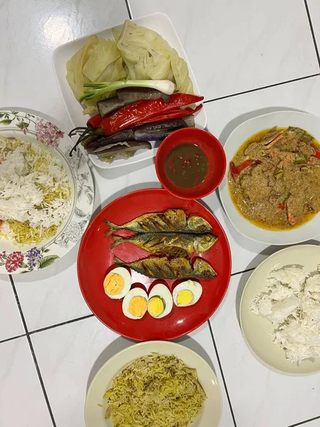 Yanında haşlanmış sebze, haşlanmış yumurta, kızarmış balık ve pilav..