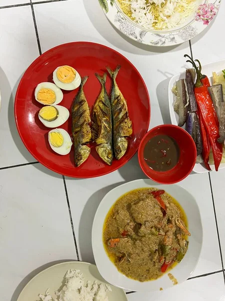 Yanında haşlanmış sebze, haşlanmış yumurta, kızarmış balık ve pilav..