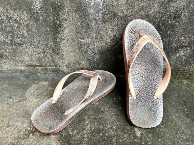 Kirli arka planda eski terlikleri kapat