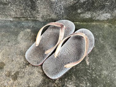 Kirli arka planda eski terlikleri kapat