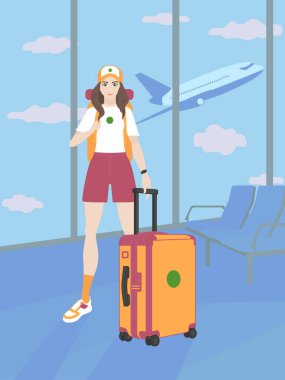 Girl tourist stands with luggage waiting for the departure of the flight at the international airport. The woman is dressed in light sportswear, with a suitcase, a backpack on her back and a yoga mat.