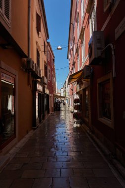 Zadar, Hırvatistan - 7 Ağustos 2021 - Eski balıkçı kasabasının dar sokakları yaz güneşli öğleden sonra                               