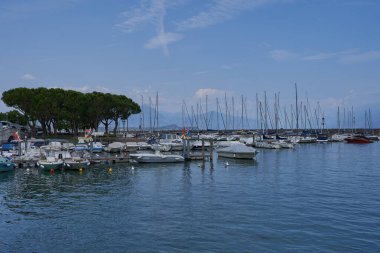 Desenzano del Garda, Italy - July 12, 2022 - yachts and boats docked at the port on Lake Garda on a sunny summer morning                               