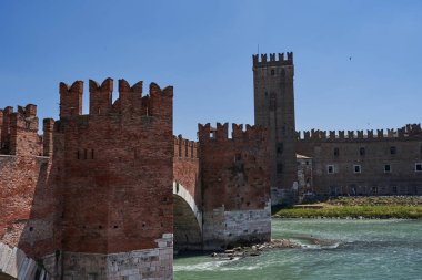 İtalya 'nın Verona kentindeki Adige nehri boyunca uzanan Castelvecchio Kalesi' ne bağlı Castel Vecchio Köprüsü (veya Scaliger Köprüsü) manzarası - Temmuz 2022                               