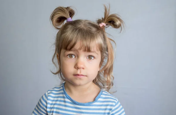 一个头戴马尾辫 身披浅色背景的4岁女孩的情感画像 — 图库照片