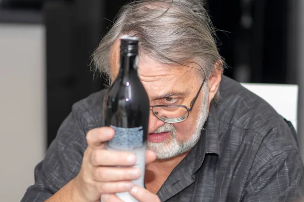 Gråhårig Man Med Glasögon Försöker Läsa Etiketten Flaskan Finstilt Dålig — Stockfoto