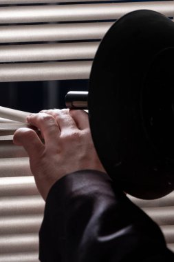 Özel bir dedektif, casus cihazları, seçici odaklanma, yakın çekim, pencerenin perdelerinden konuşmaları dinlemek ve kaydetmek için yönelimli bir mikrofon topu ortaya çıkıyor..