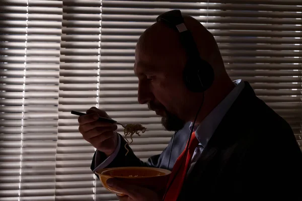 Ein Mann Anzug Und Kopfhörer Isst Pasta Vor Dem Hintergrund — Stockfoto