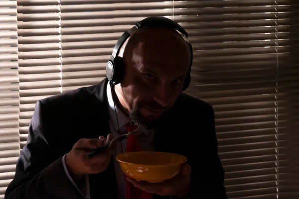 Hombre Con Traje Auriculares Come Pasta Contra Fondo Una Ventana — Foto de Stock