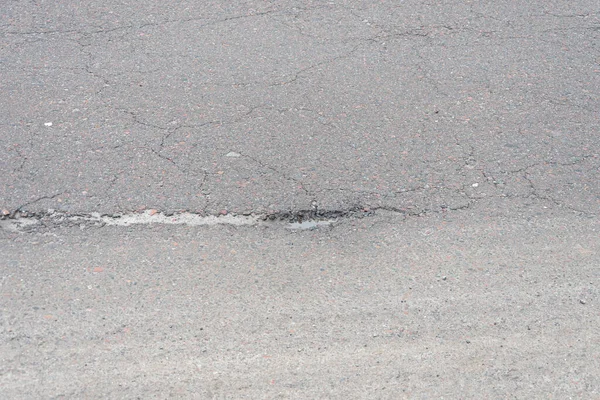 雨后沥青路面上的一个洞 春天过后道路上的一个坑洞融化了 — 图库照片