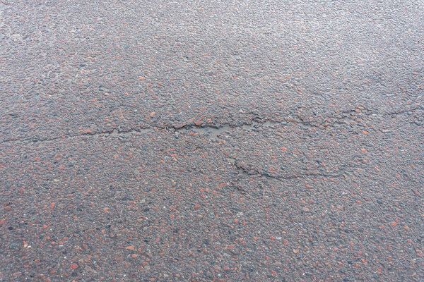 Дыра в асфальте после дождя, выбоина на дороге после весенней оттепели.