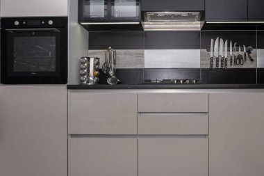 Dairenin içinde modern bir mutfak, dolaplar, fırın, gaz sobası, yemek masası..