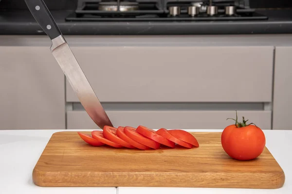 Kuchyňský Nůž Zasekne Prkna Kuchyni Stole Leží Nakrájená Červená Rajčata — Stock fotografie