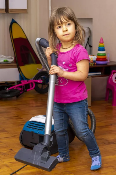 Küçük bir kız odayı süpürüyor, her şeyi düzene sokuyor. Daireyi temizliyorum..