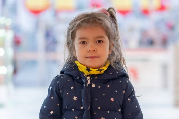 在购物中心里一个背景模糊的金发小女孩的画像 — 图库照片