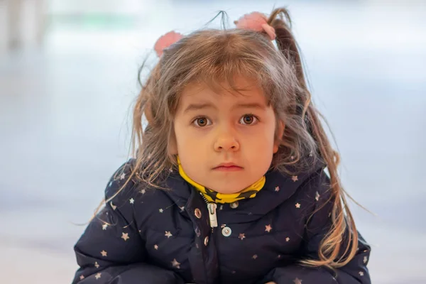 一个金发碧眼的小女孩在购物中心里模糊的背景上的感人画像 脸上严肃的表情 — 图库照片