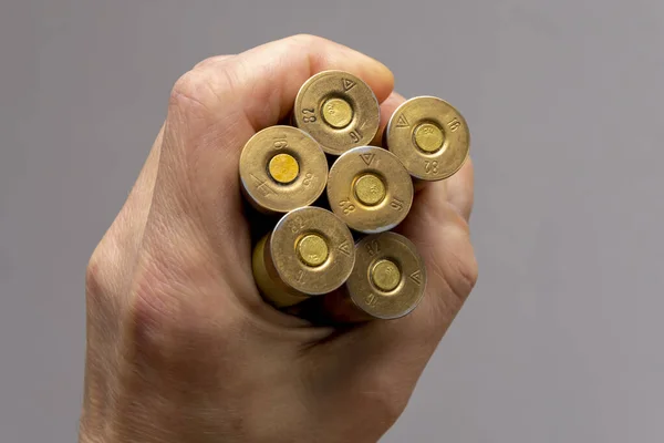 Hunting cartridges are clamped in a man\'s hand.  Concept: male hobby, bird hunting, large caliber.