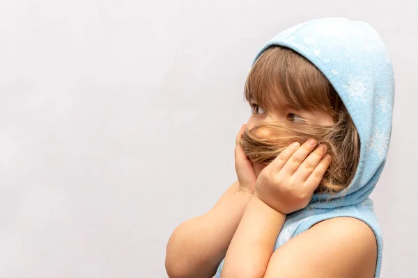 一个穿着蓝色连帽衫 身披浅色背景 惊慌失措的小女孩的动人画像 — 图库照片