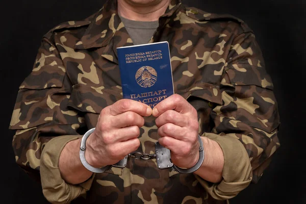 手錠をかけられた捕虜はベラルーシのパスポートを手に持ってる ジュネーブ条約戦争捕虜の人道的取り扱い — ストック写真