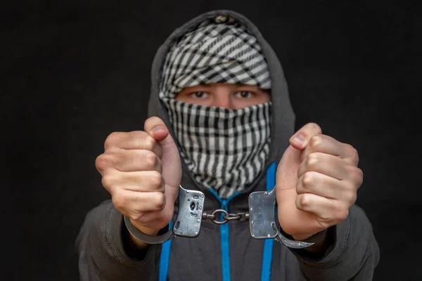 一个戴手铐的男人用手帕把脸掩藏在黑色背景下 有选择性地聚焦 一个顽固的犯罪 刑事责任 犯罪集团和团伙成员 — 图库照片