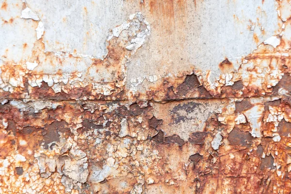 The texture of brown rust and stains on the old metal surface, selective focus. Metal corrosion, peeling paint.