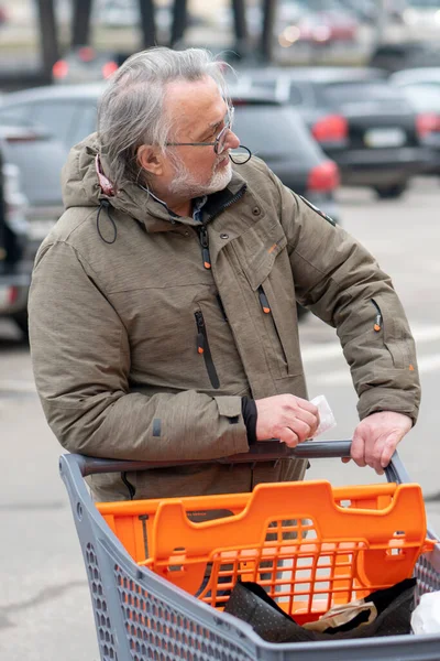 Ένας Ηλικιωμένος Άντρας Ηλικίας Ετών Σπρώχνει Ένα Καροτσάκι Στο Πάρκινγκ — Φωτογραφία Αρχείου