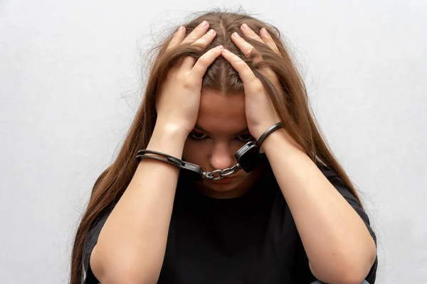 灰色の背景に クローズアップ手錠をかけられた若い女の子 黒のTシャツの少年非行 未成年者の刑事責任 — ストック写真