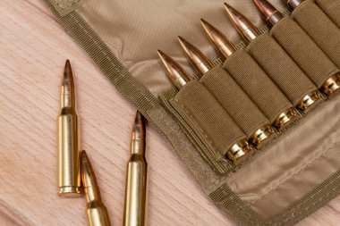 Kalaşnikof saldırı tüfeği için 7.62 kalibrelik bir askeri bandocuda kurşun bulunan sarı tüfek fişekleri..