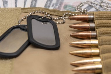 Amerikan doları banknotlarında ordu kimlik madalyonları, gerçek cephanesi olan bandocular. Konsept: Askeri özel operasyon, silah malzemeleri, savaşın finansmanı, kiralama, silah satışı, askeri emeklilik maaşı, orduda maaş, sigorta