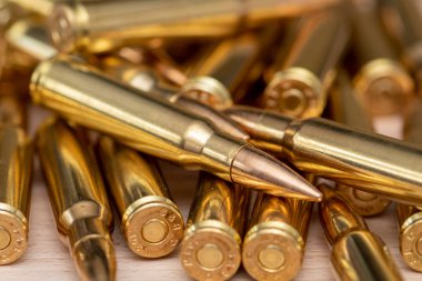 Kalaşnikof taarruz tüfeği için 7.62 kalibrelik mermilerin etrafa saçılması, yakın plan, seçici odaklanma. Konsept: ödünç verilmiş silah satışı, mühimmat yardımı, silah tedariği.